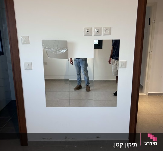 מראה שבורה על קיר עם שקעים חשמליים